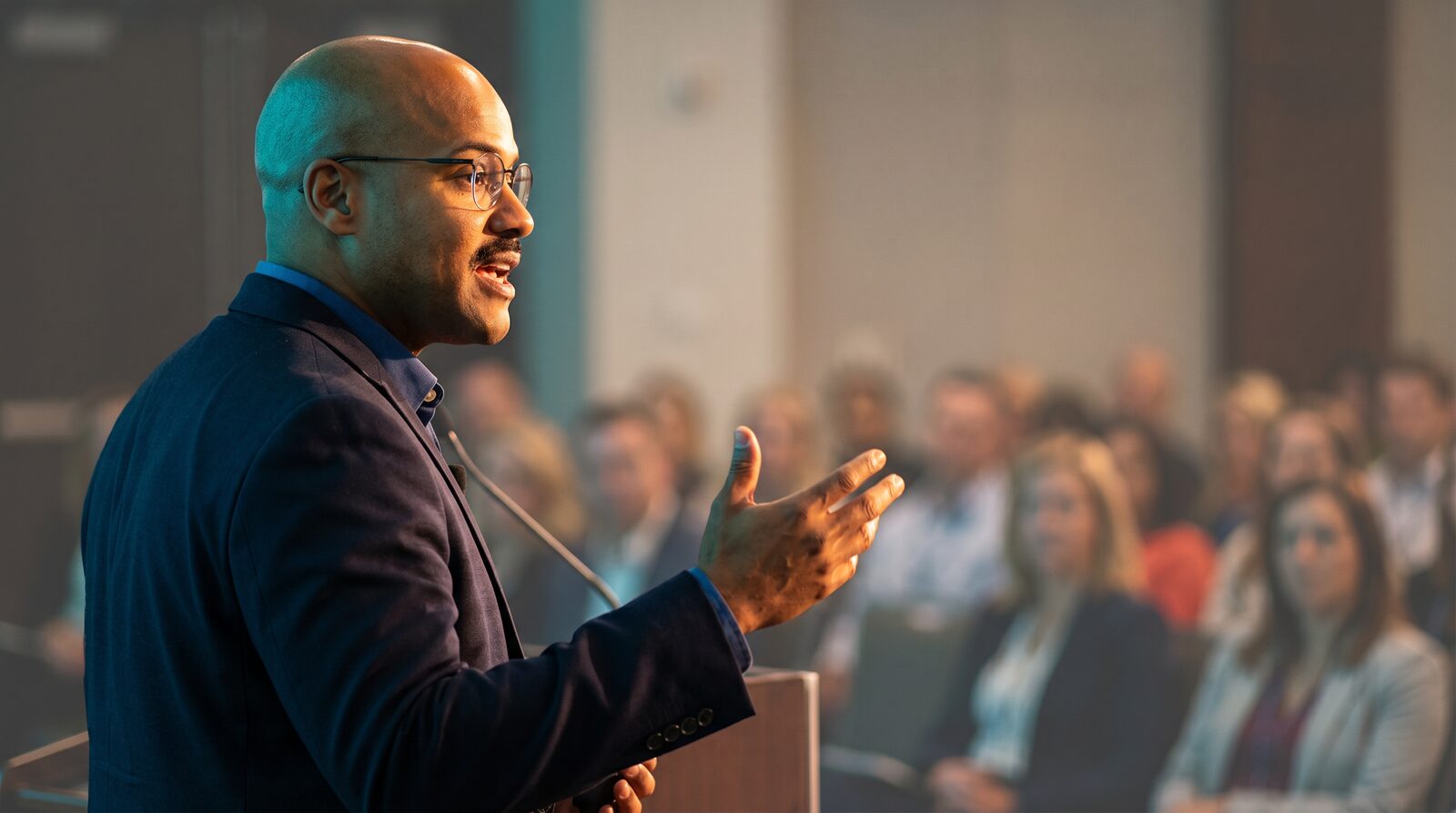 Dr. Bullard speaking to an engaged audience — a physician who commands the room